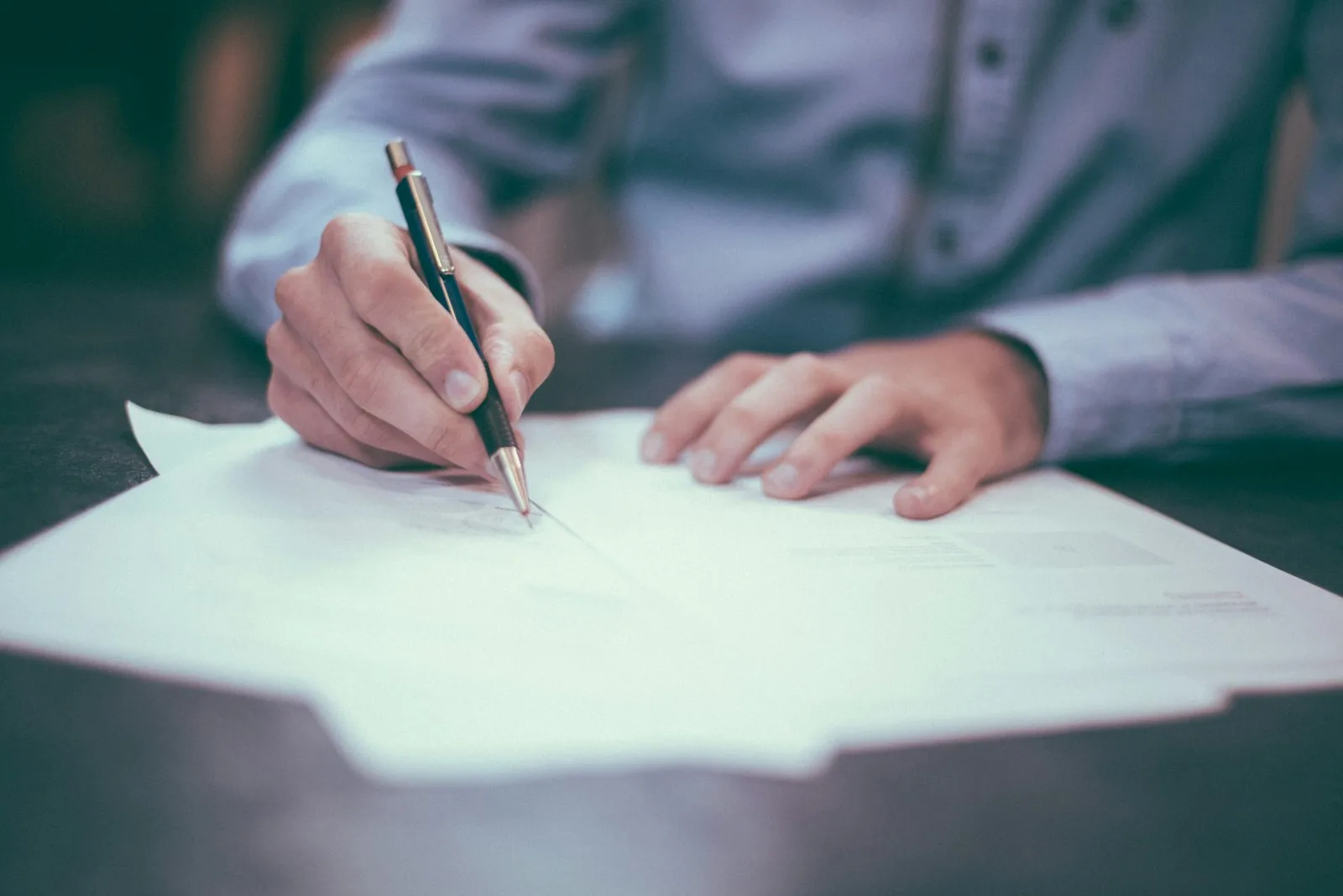 Contract documents and a pen on a desk representing consent paperwork for event coverage.